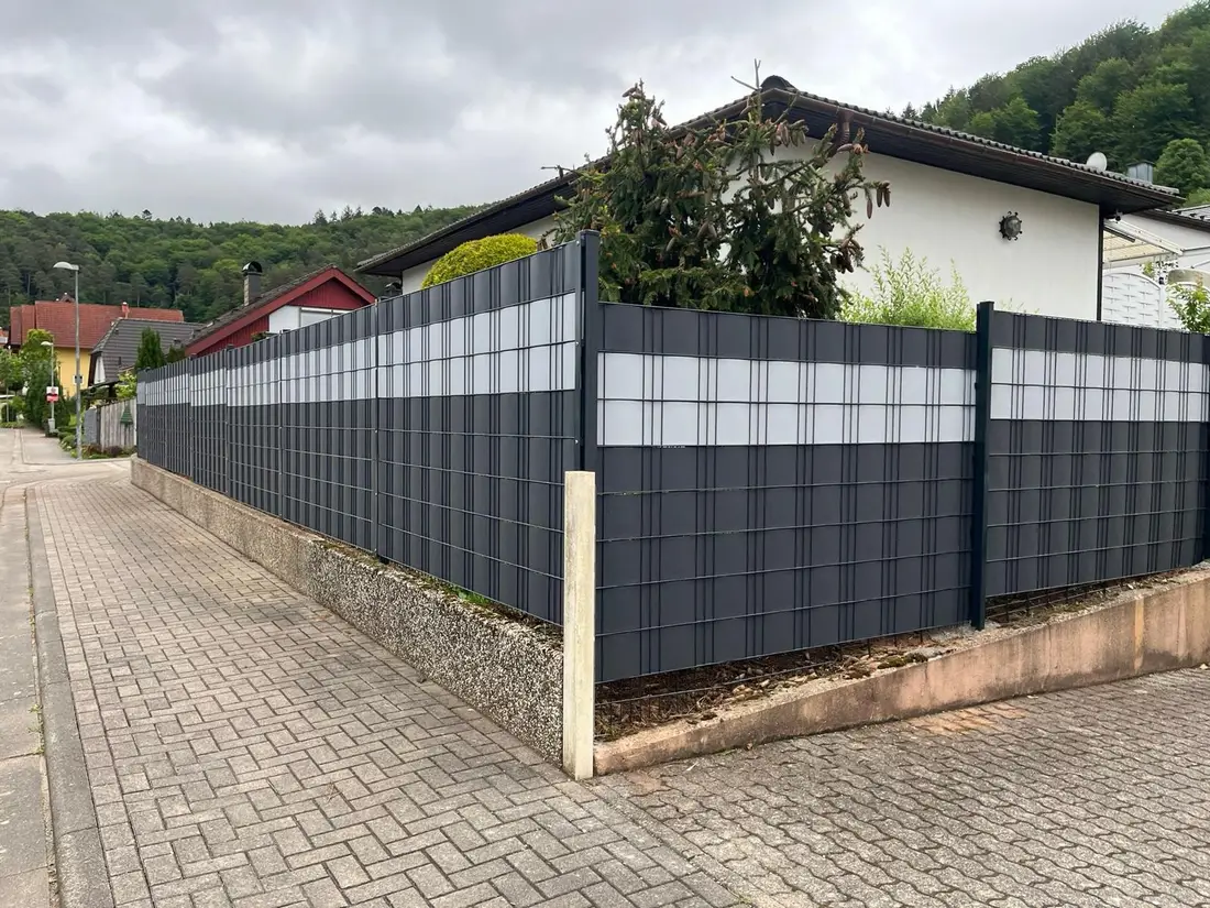 Eckausbildung eines Doppelstabmattenzauns mit Sichtschutzstreifen auf einer Mauer in Waldfischbach-Burgalben